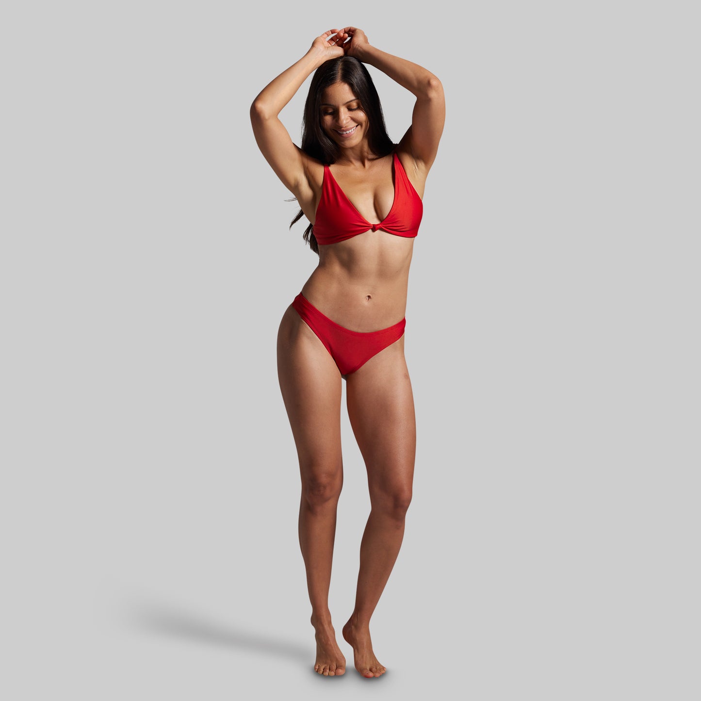 Woman wearing a red bikini against a gray background