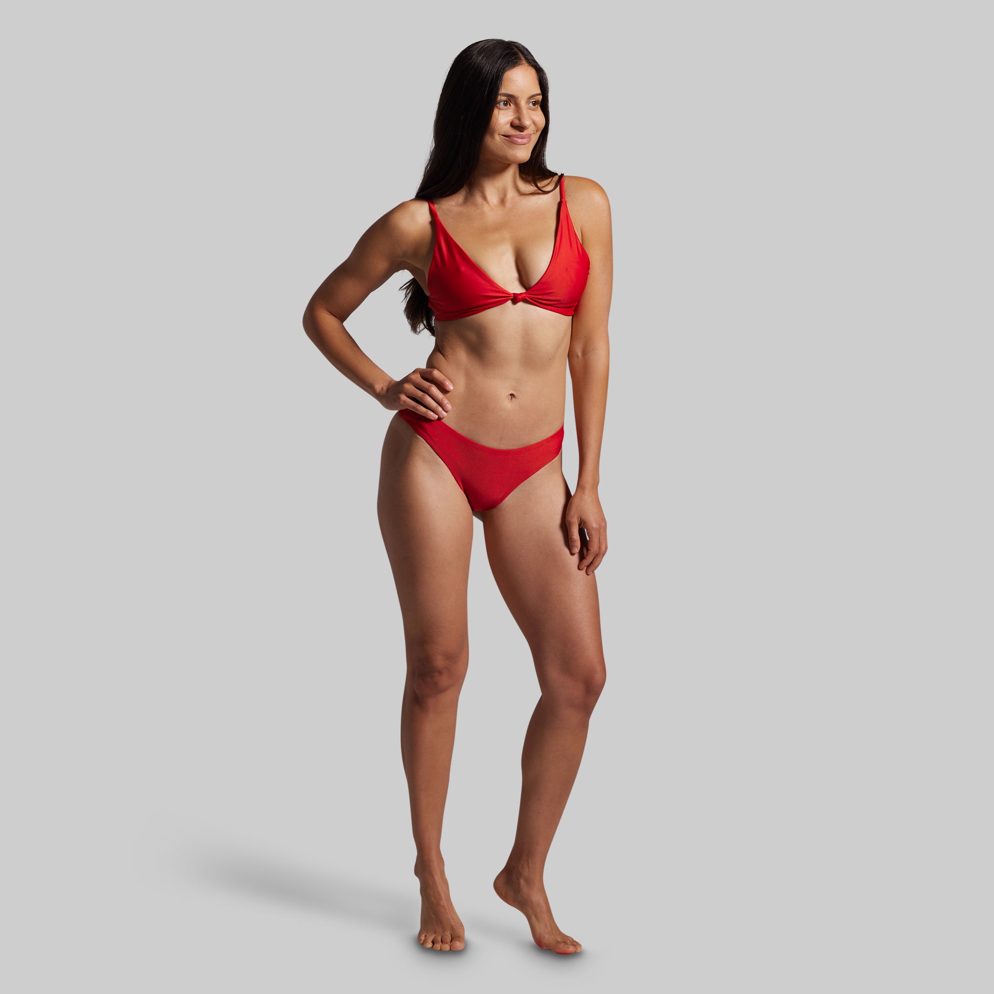 Woman wearing a red bikini against a gray background