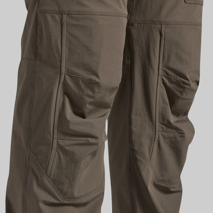 Close-up of grey outdoor cargo pants showing the detailed pocket construction and fabric texture.