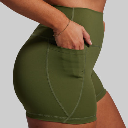Green athletic shorts worn by a person on a gray background