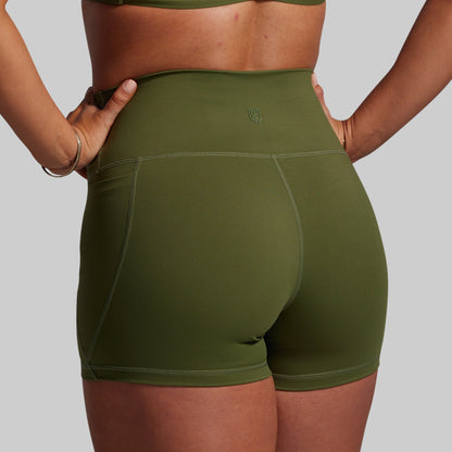 Green athletic shorts worn by a person on a gray background
