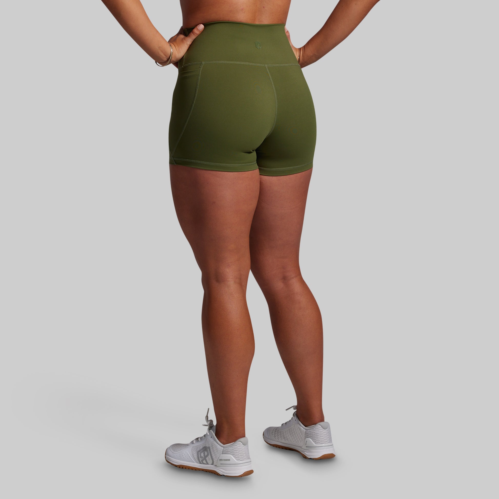 Person wearing green athletic shorts on a gray background