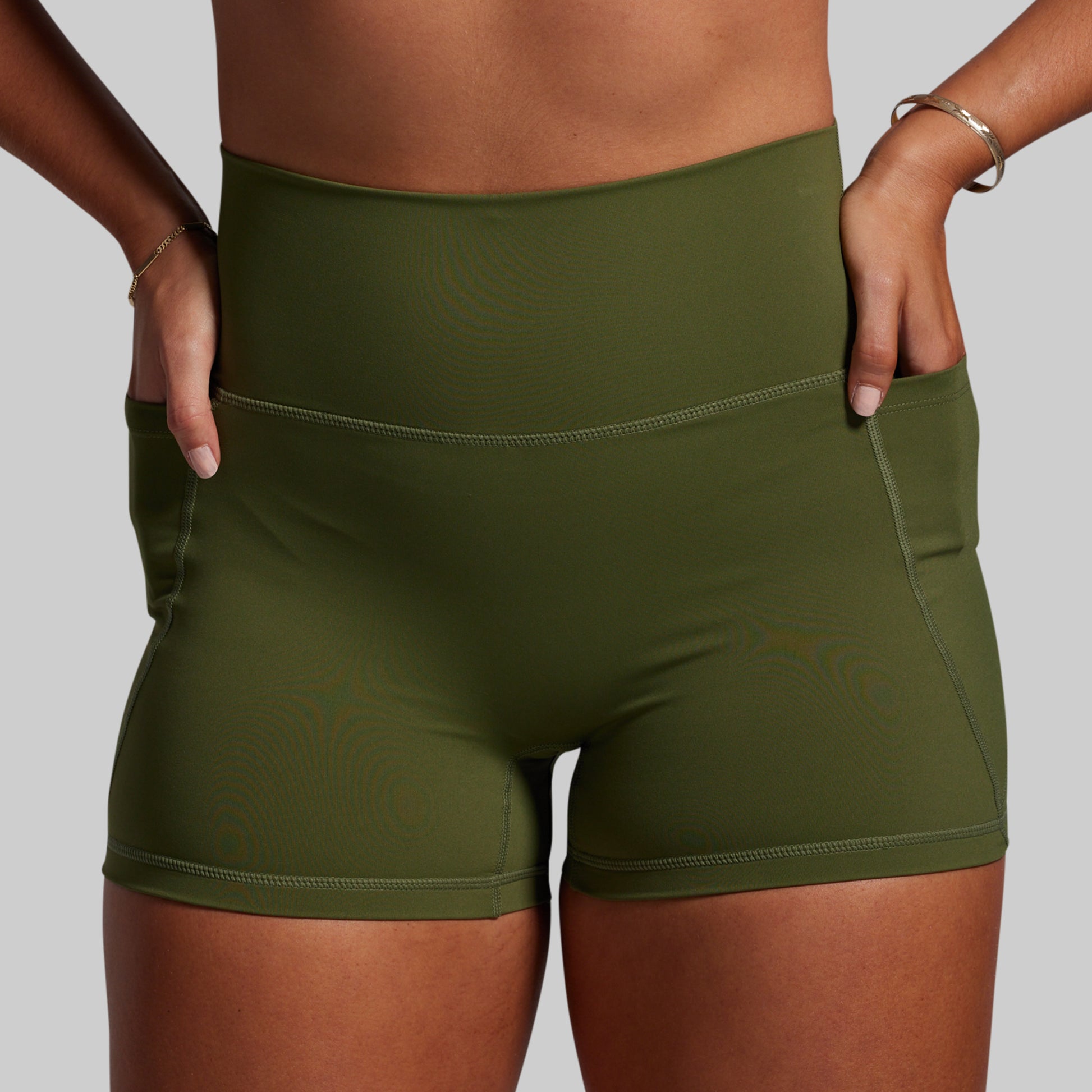 Green athletic shorts worn by a person on a plain background