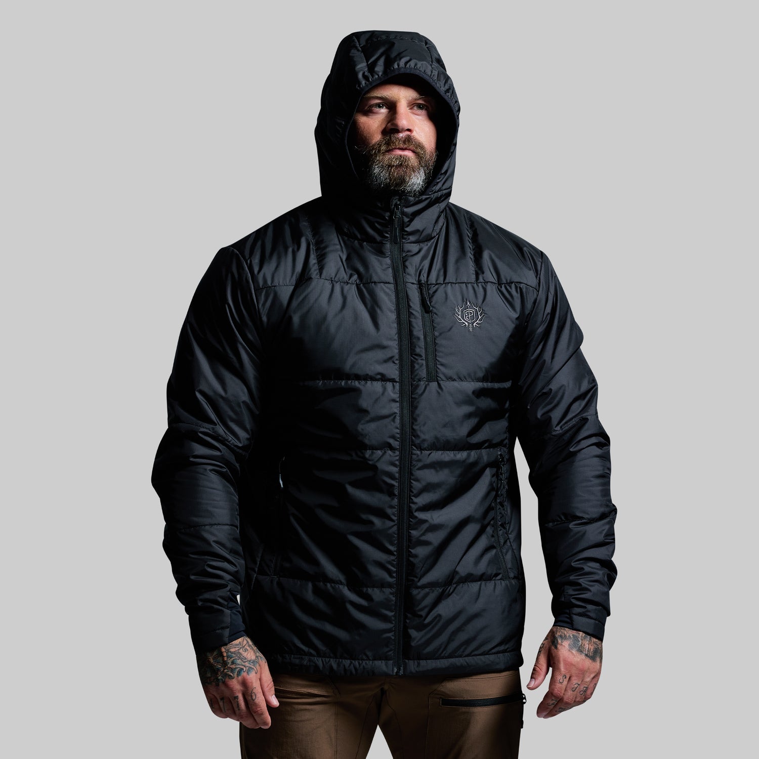 Man wearing a black puffer jacket on a gray background