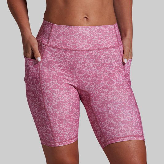 Pink patterned shorts worn by a person on a gray background