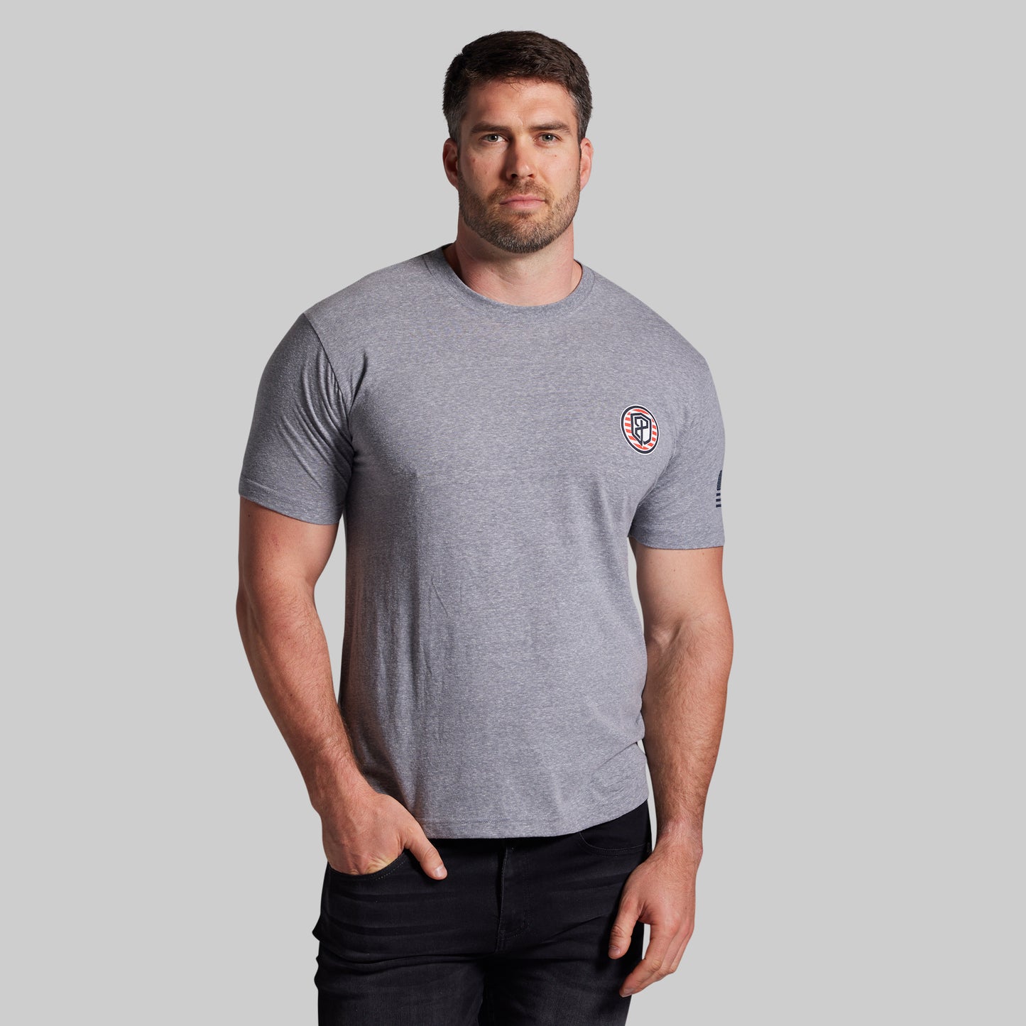 Man wearing a gray t-shirt with a logo on a light gray background