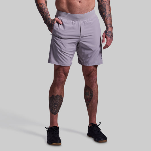 Person wearing light gray shorts on a plain background