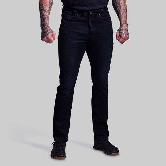 Person wearing black jeans on a plain background