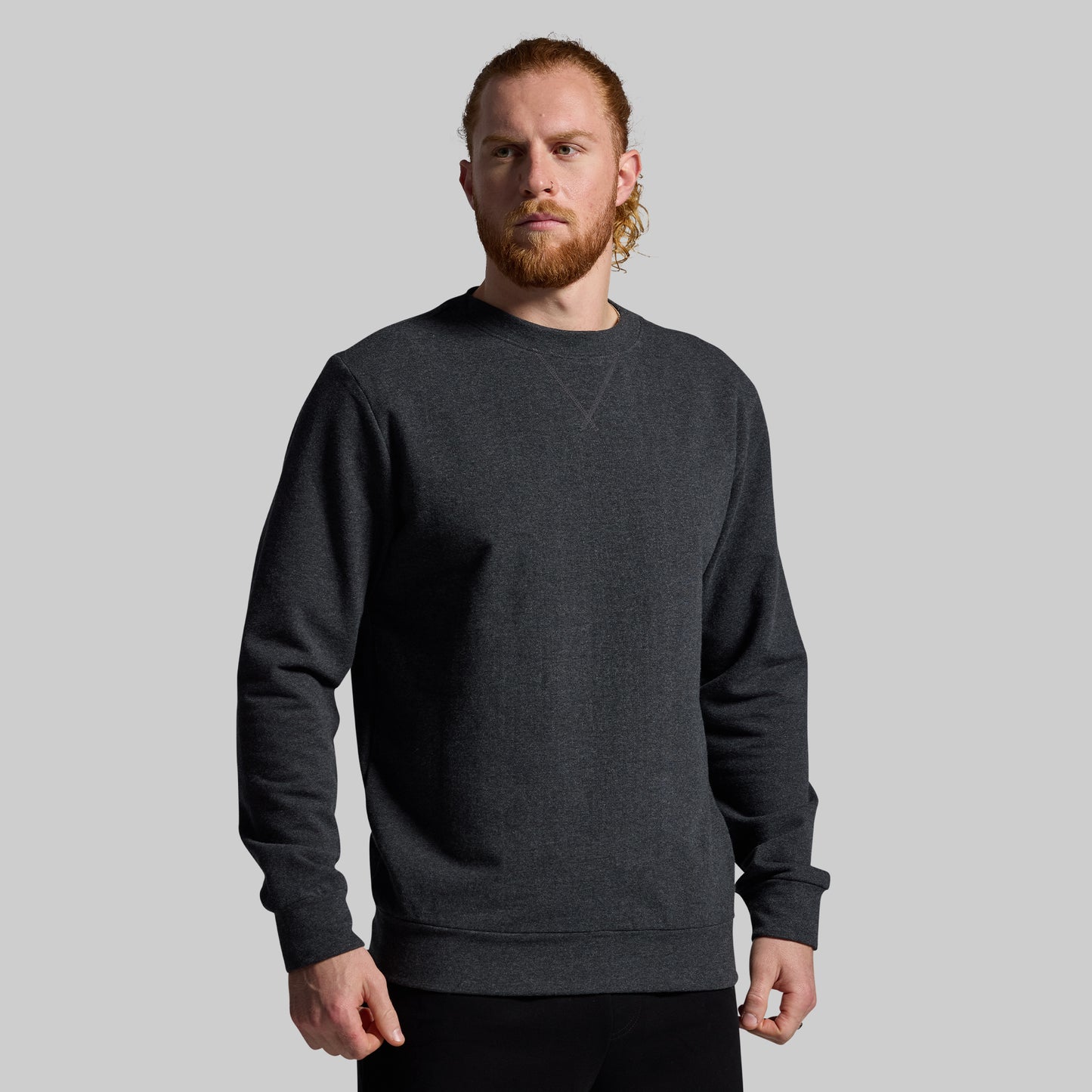 Man wearing a dark gray sweatshirt against a plain background