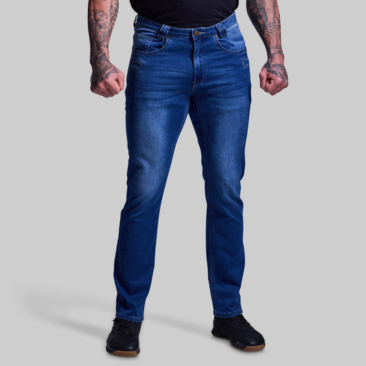 Person wearing blue jeans on a plain background