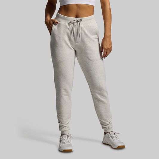 Person wearing light gray sweatpants on a plain background