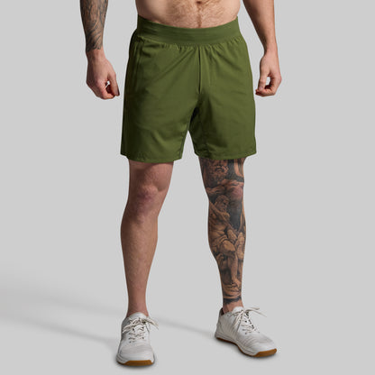 Person wearing green shorts on a plain background