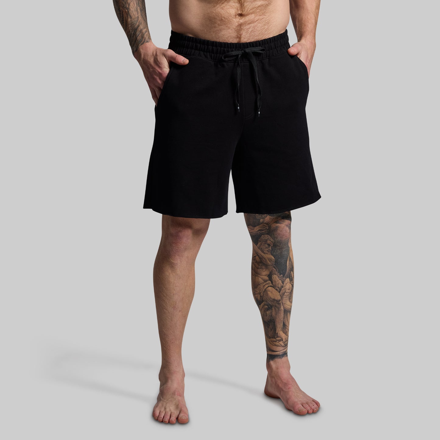 Person wearing black shorts on a gray background