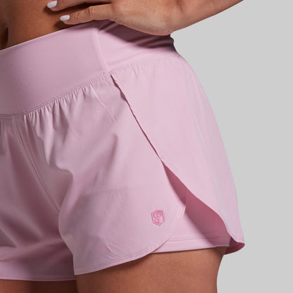Pink athletic shorts with a brand logo on a neutral background