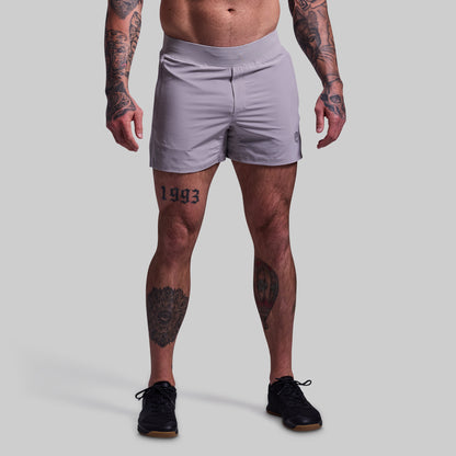Person wearing light gray athletic shorts on a plain background
