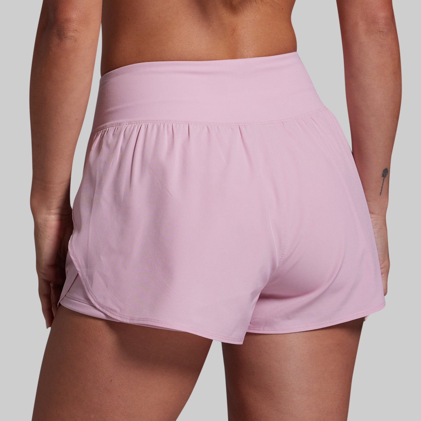 Pink athletic shorts worn by a person on a plain background