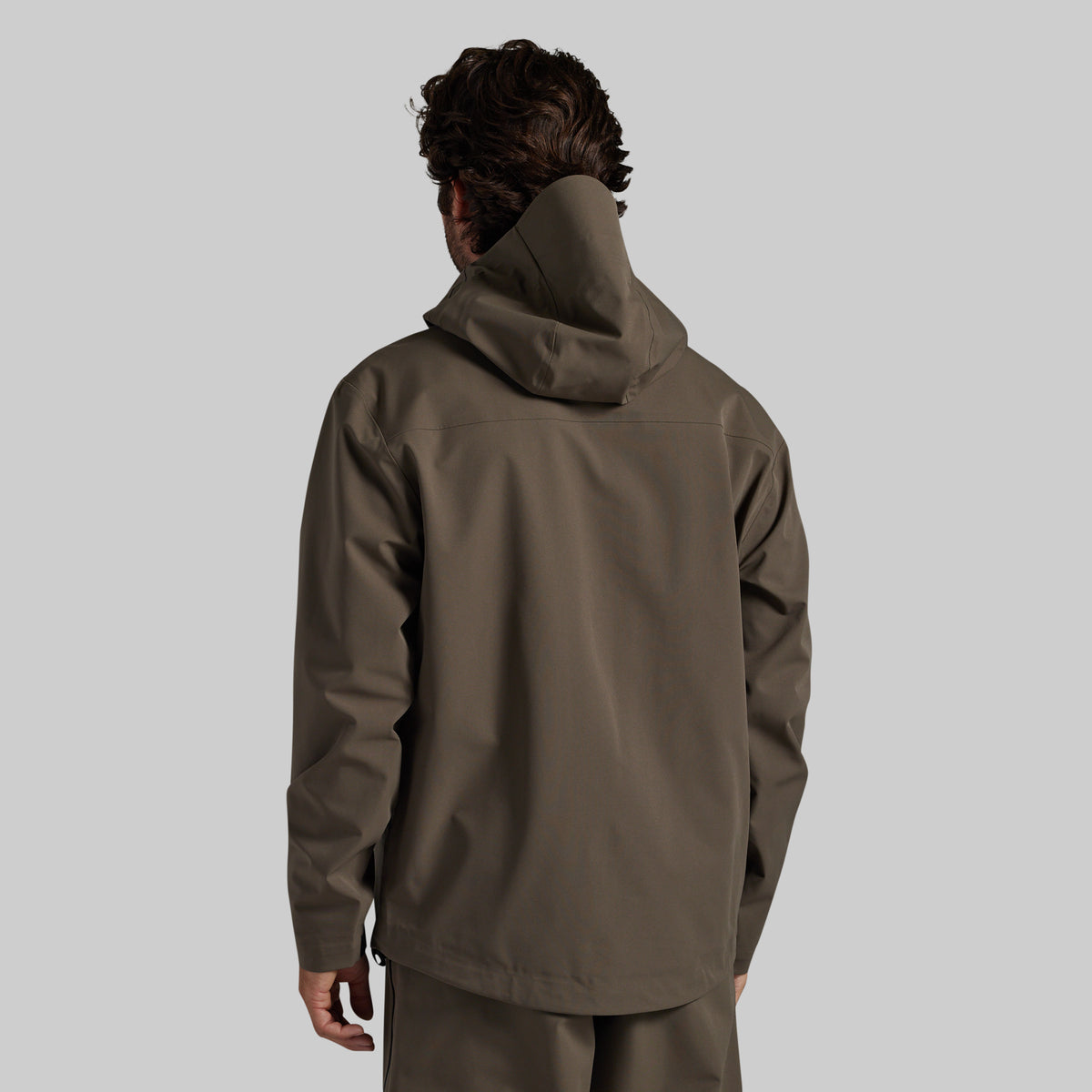 Man wearing the Ranger Green Mission FLEX Rain Jacket 2.0, back view