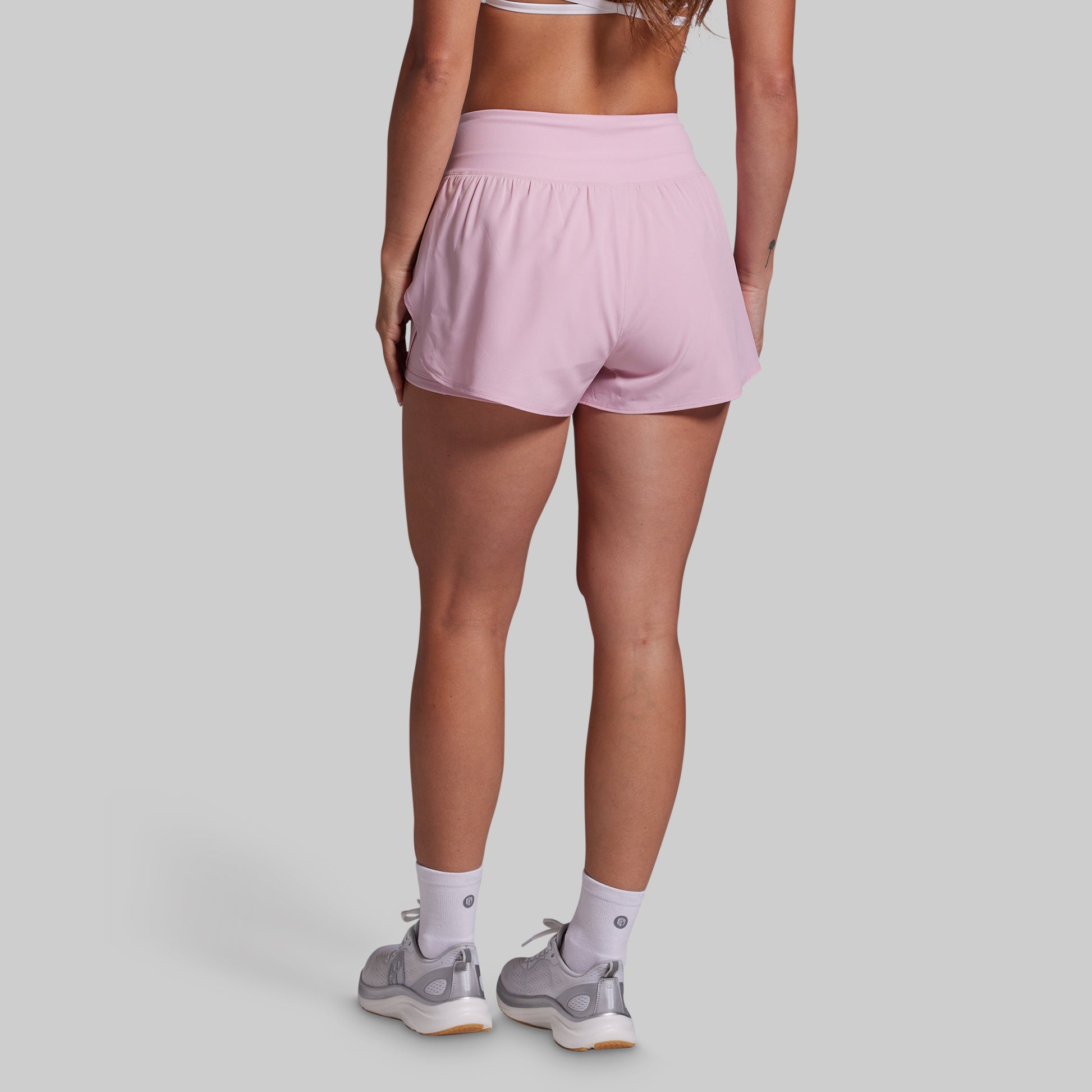 Person wearing pink shorts on a plain background
