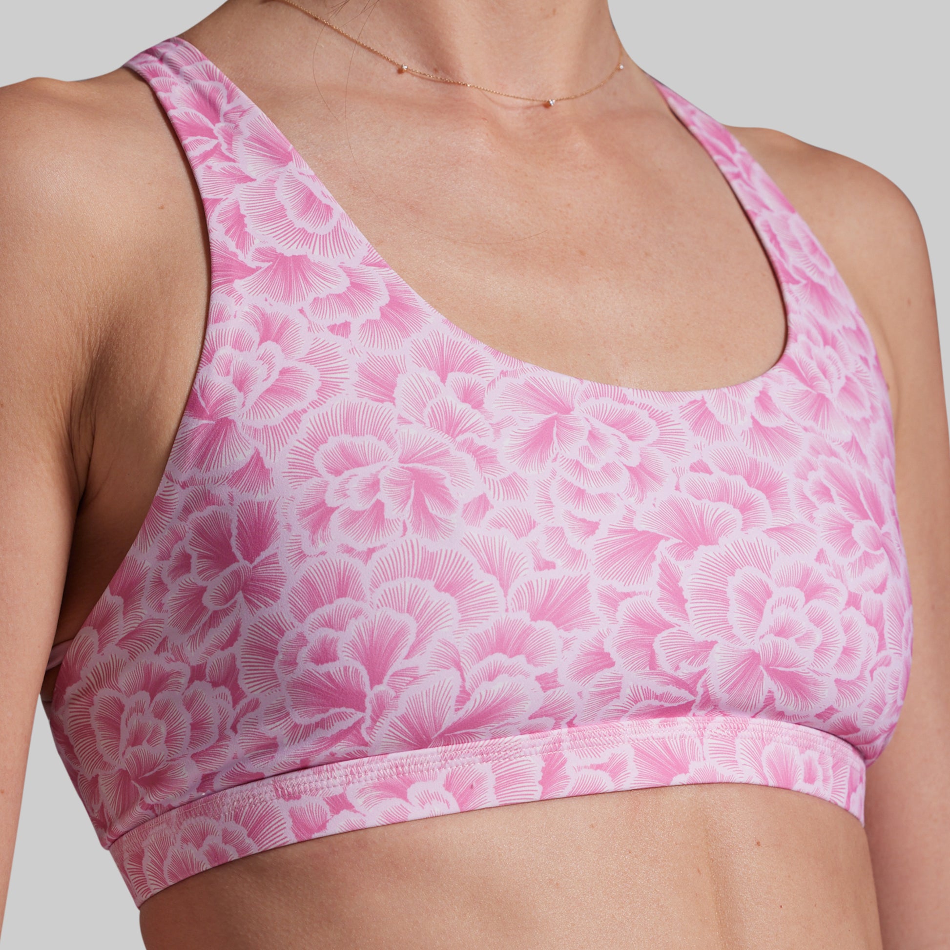 Pink floral sports bra on a neutral background