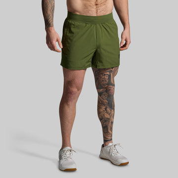 Person wearing green shorts on a plain background