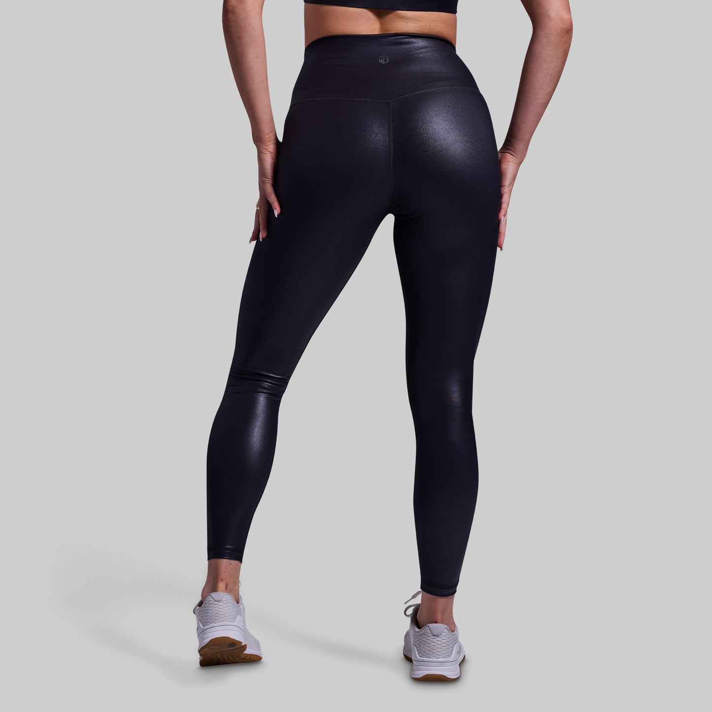 Person wearing black leggings on a light gray background