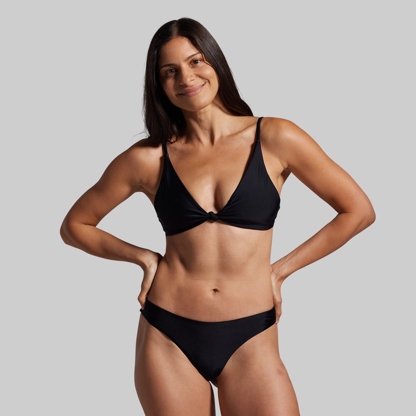 Woman wearing a black bikini against a gray background