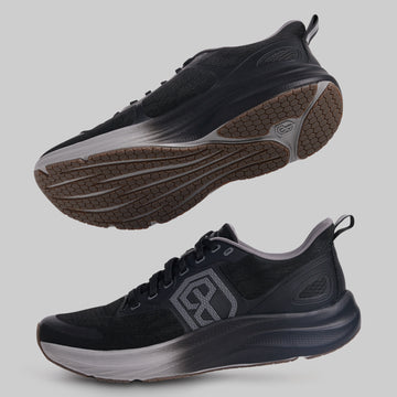 Black athletic shoes with a brand logo on a gray background