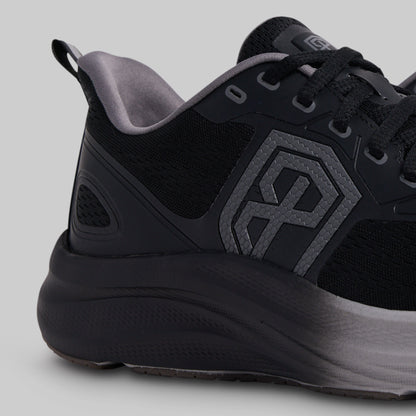 Black athletic shoe with a geometric logo on a gray background
