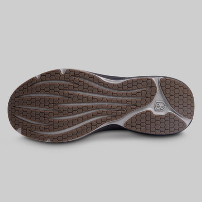 Close-up of a shoe sole with a textured pattern on a gray background