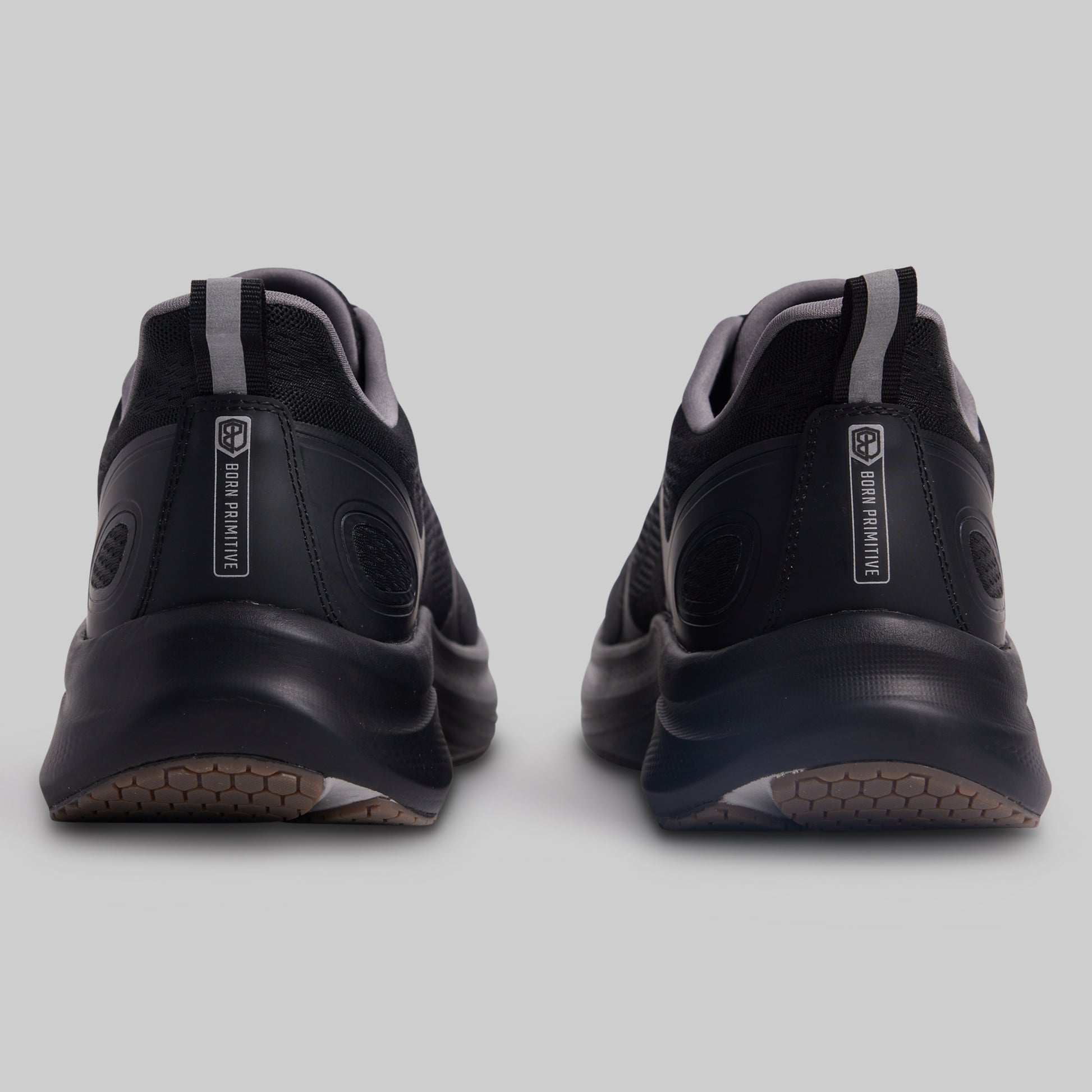 Black athletic shoes with visible branding on a light gray background