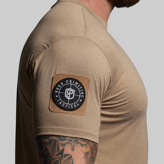 Beige t-shirt with a patch on the sleeve against a gray background