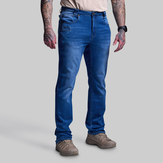 Person wearing tactical blue jeans on a plain background