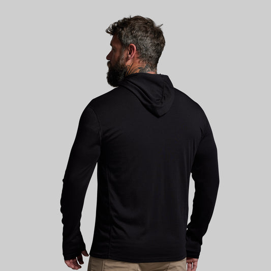 Man wearing a black hoodie from behind on a gray background