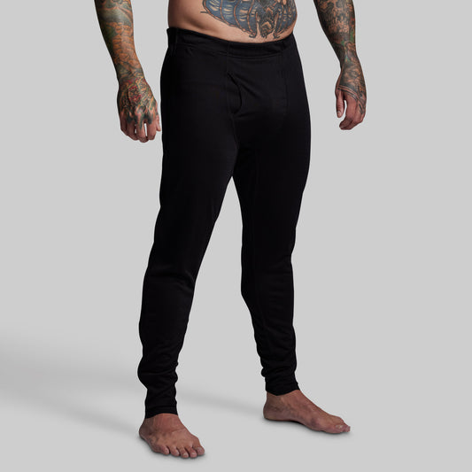 Person wearing black pants on a gray background