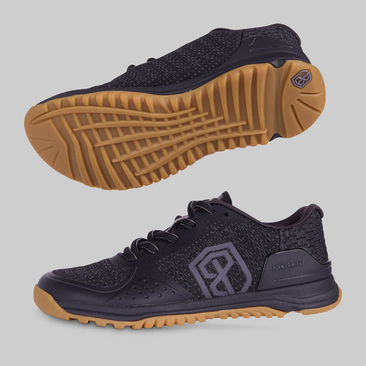 A pair of training shoes with black upper mesh material and a gum-colored outsole.
