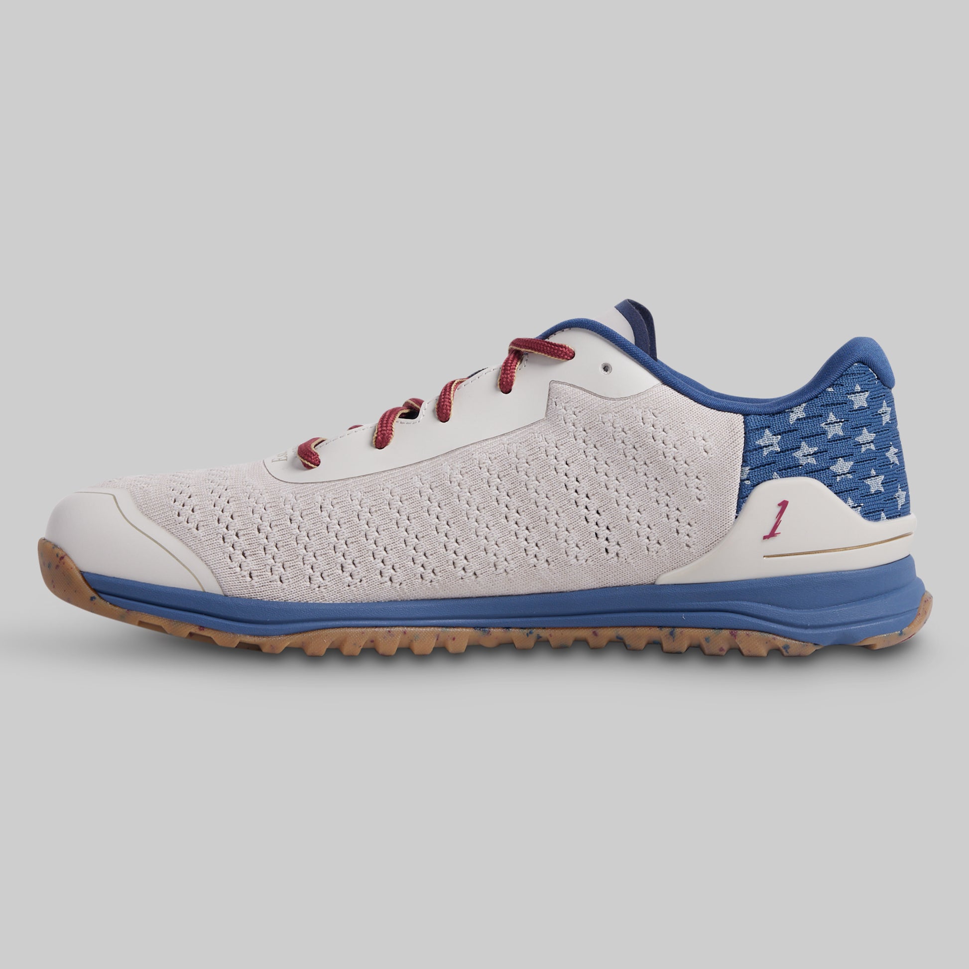 White and blue sneaker with red accents on a gray background