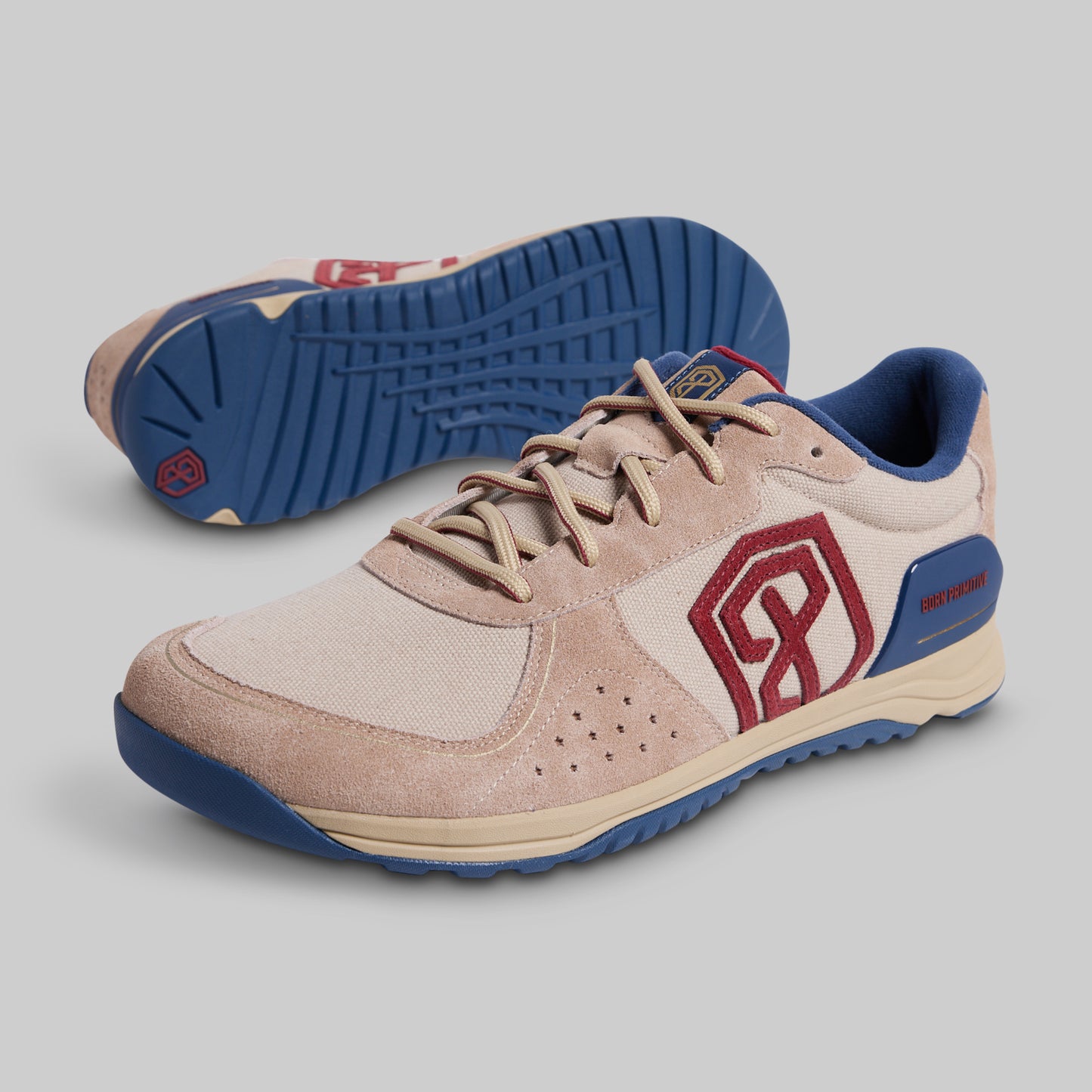 Beige and blue athletic shoe with red logo on a gray background