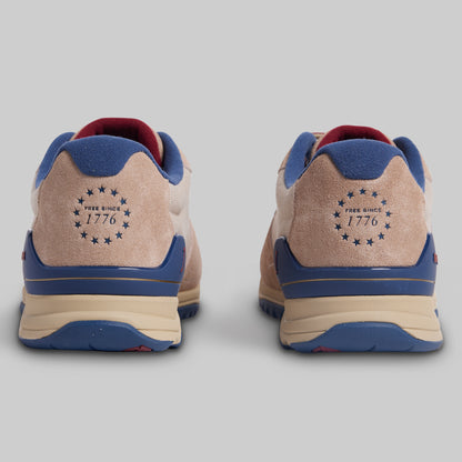 Pair of sneakers with 'Free Since 1776' logo on a gray background