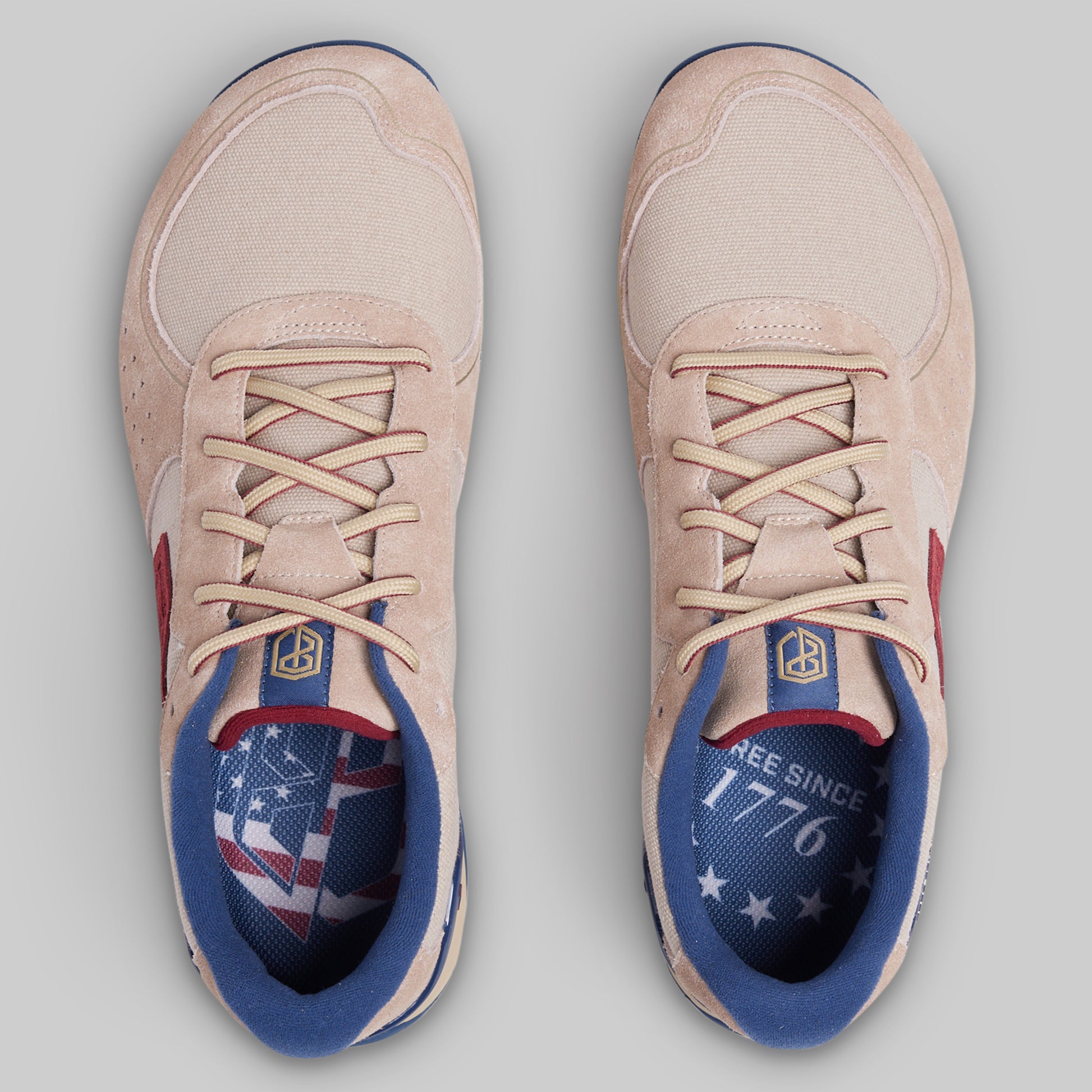 Pair of beige sneakers with American flag design on a gray background