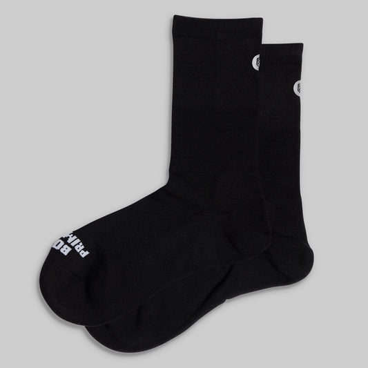 Black socks with white branding on a light gray background