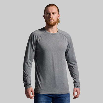 Man wearing a gray long-sleeve shirt against a plain background
