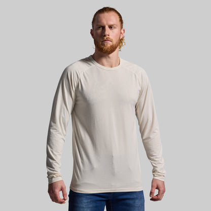 Man wearing a beige long-sleeve shirt against a plain background