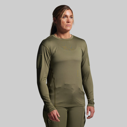 Person wearing an olive green long-sleeve tactical shirt and pants on a gray background