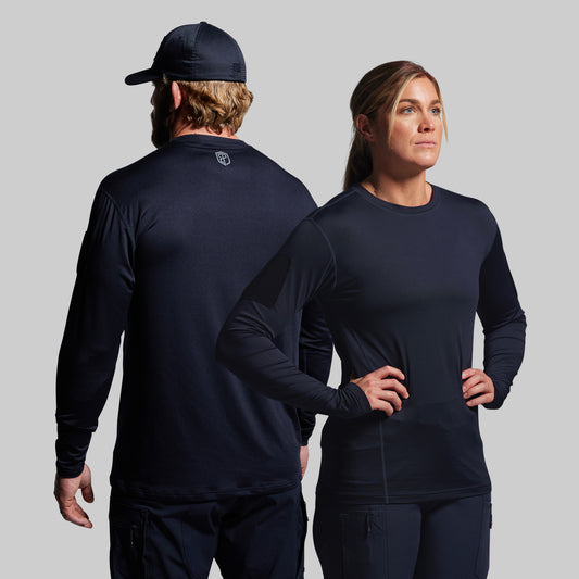 Two people wearing navy long-sleeve tactical shirts on a gray background