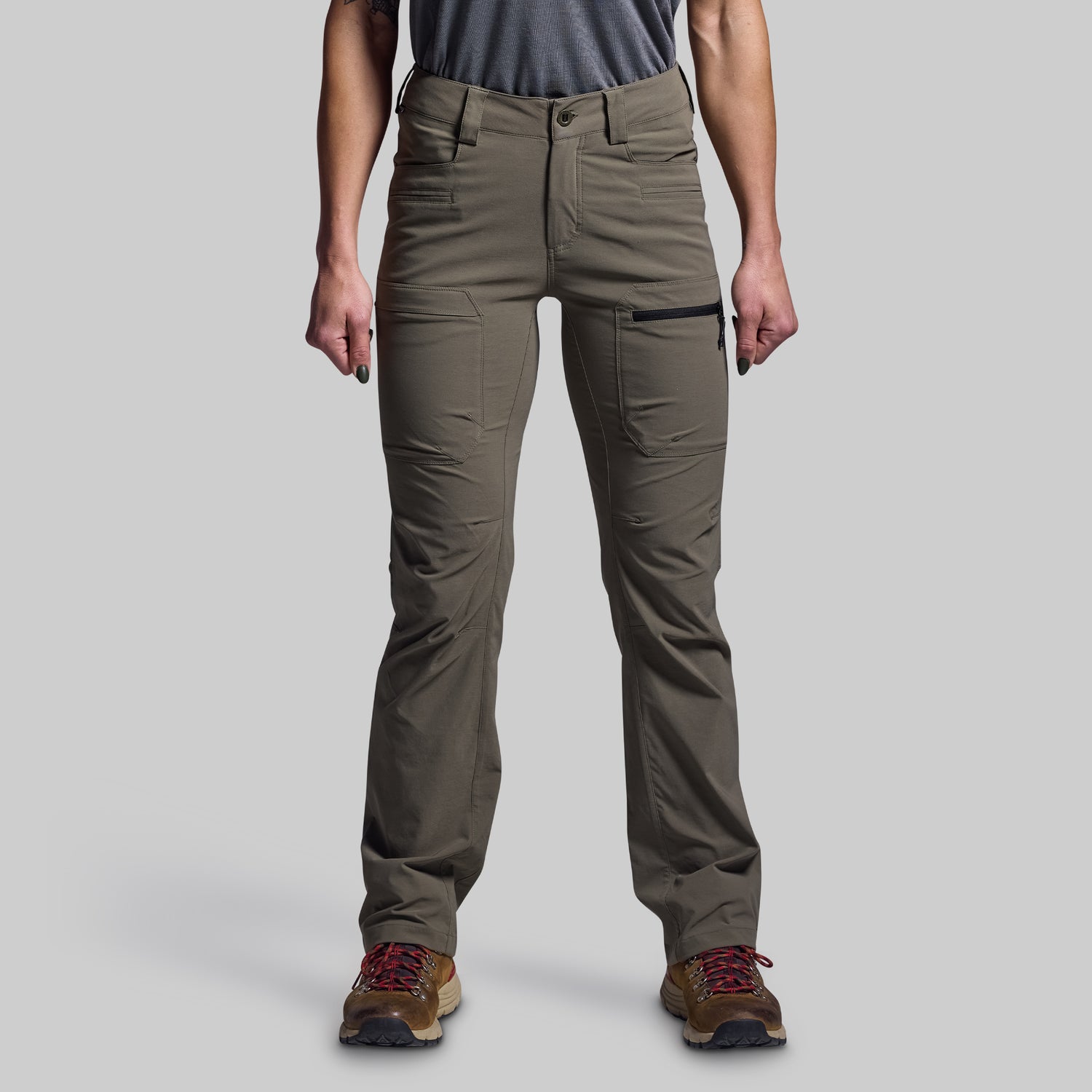 Person wearing green pants on a gray background