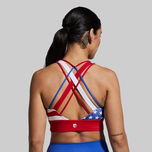 Person wearing a sports bra with American flag design on a plain background
