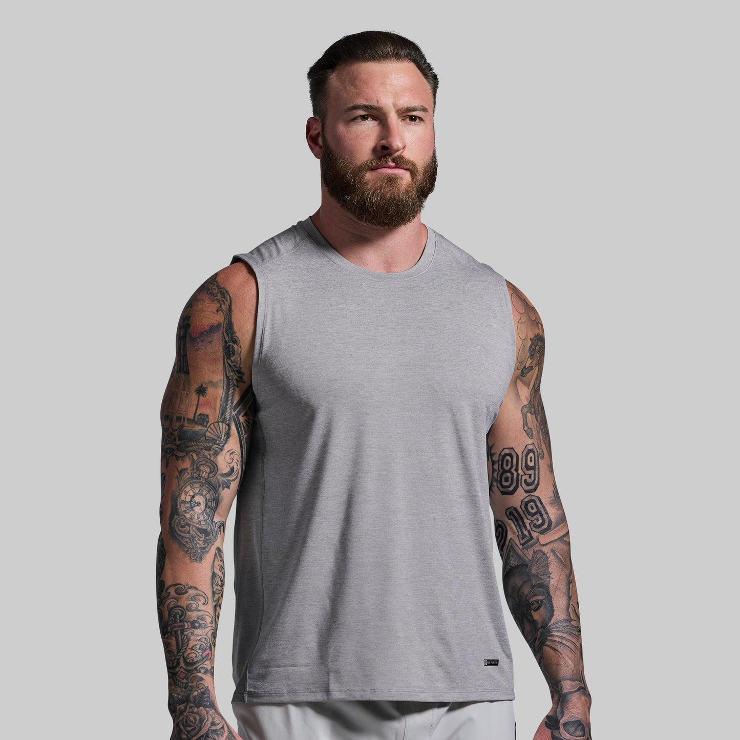 Man wearing a gray sleeveless shirt against a plain background