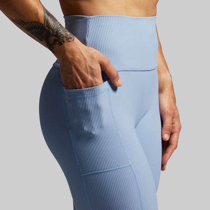 Light blue leggings worn by a person on a gray background