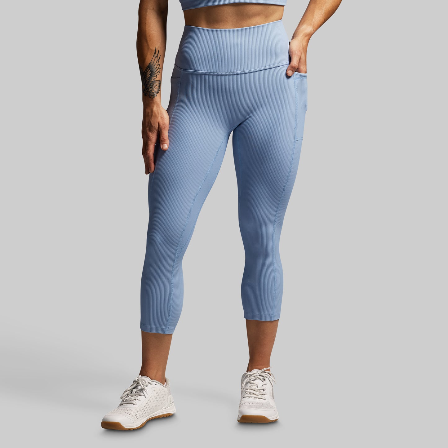Person wearing light blue leggings on a gray background