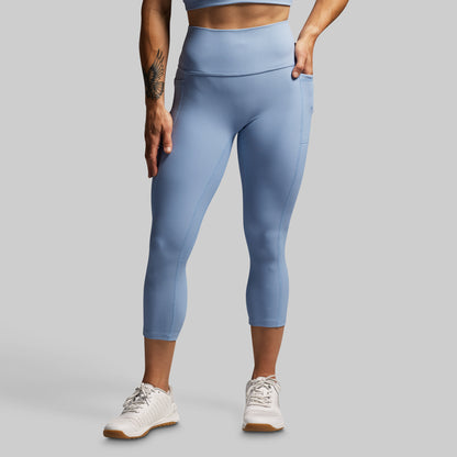 Person wearing light blue leggings on a gray background